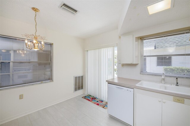 kitchen featuring visible vents, white dishwasher, a sink, and an inviting chandelier