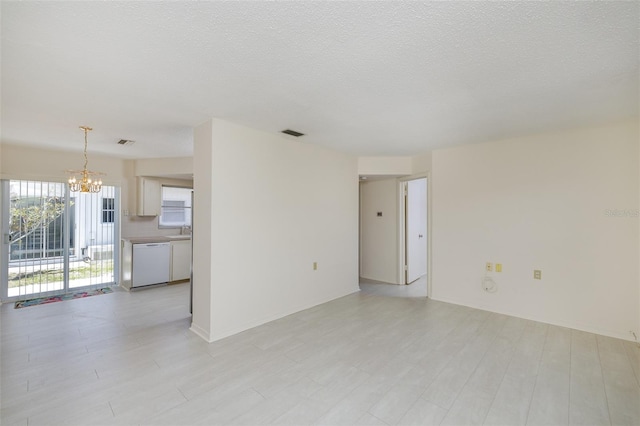 unfurnished living room with a chandelier, a sink, visible vents, and light wood-style floors
