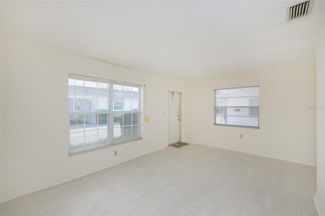 empty room featuring light wood-style flooring and visible vents