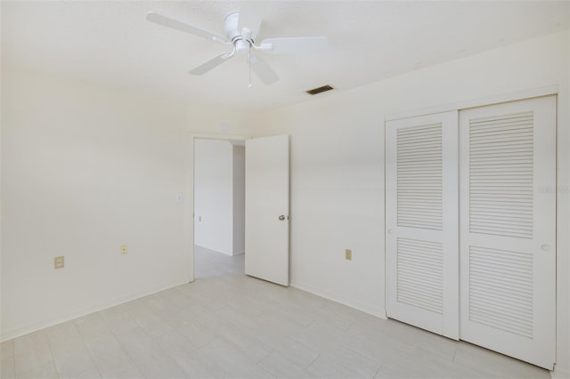unfurnished bedroom with visible vents, baseboards, ceiling fan, and a closet
