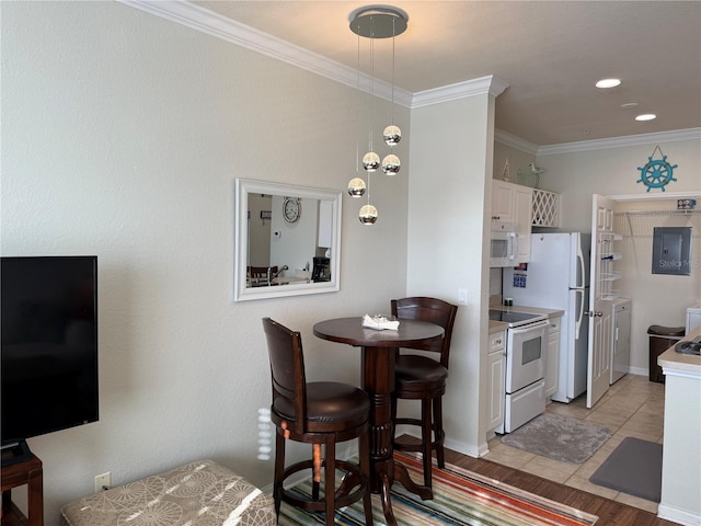 kitchen with crown molding, white appliances, white cabinetry, light countertops, and pendant lighting