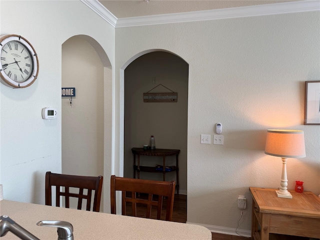 dining room with arched walkways, baseboards, and crown molding