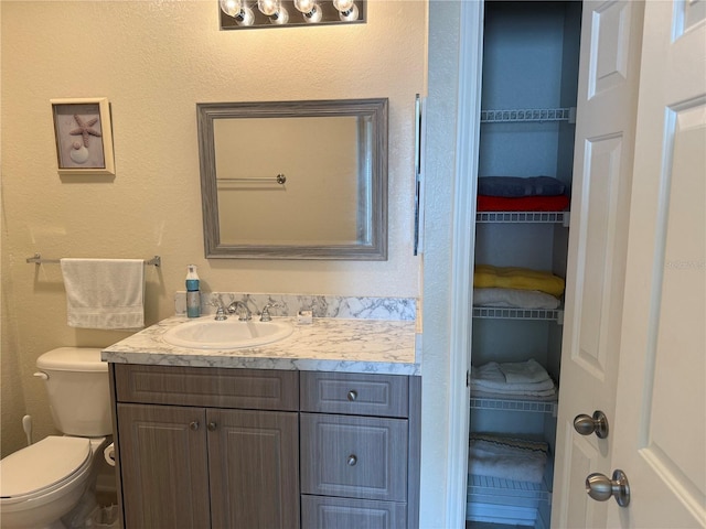 bathroom featuring toilet and vanity