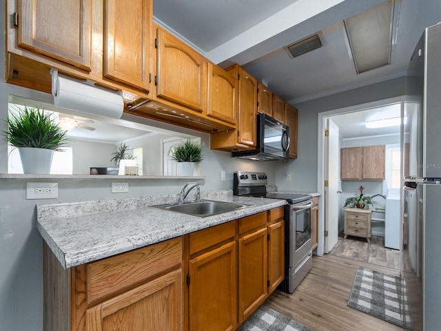 kitchen featuring stainless steel appliances, a peninsula, a sink, visible vents, and light countertops