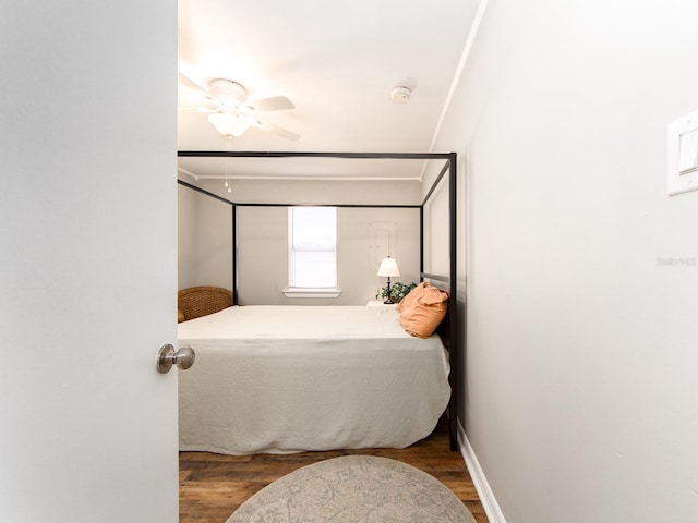 bedroom featuring dark wood-style floors, ornamental molding, and baseboards