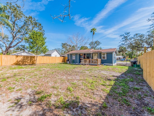 back of property featuring a fenced backyard, a deck, and a yard