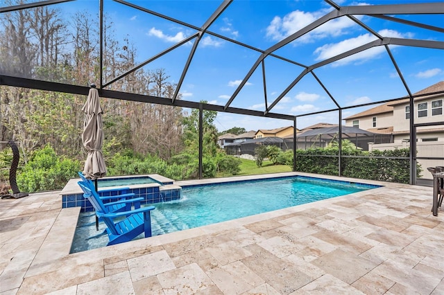 view of pool featuring a patio, a pool with connected hot tub, and glass enclosure