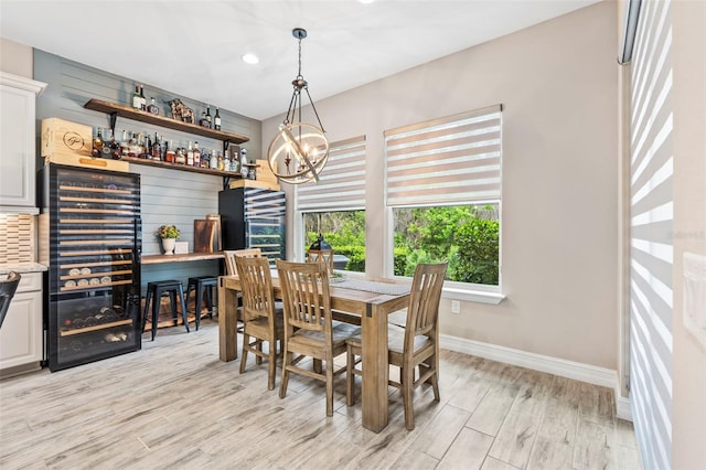 dining space featuring recessed lighting, beverage cooler, baseboards, light wood-style floors, and an inviting chandelier