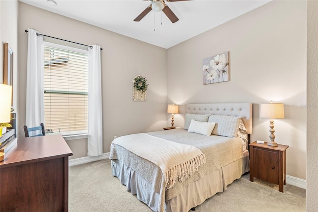 bedroom with light colored carpet, ceiling fan, and baseboards