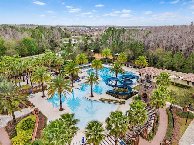 pool featuring a water slide and a wooded view