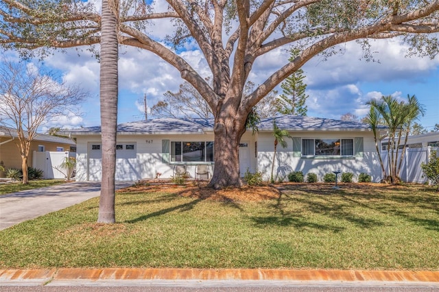 ranch-style home with driveway, a front lawn, an attached garage, and fence