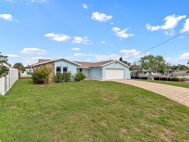 single story home with decorative driveway, stucco siding, an attached garage, fence, and a front lawn