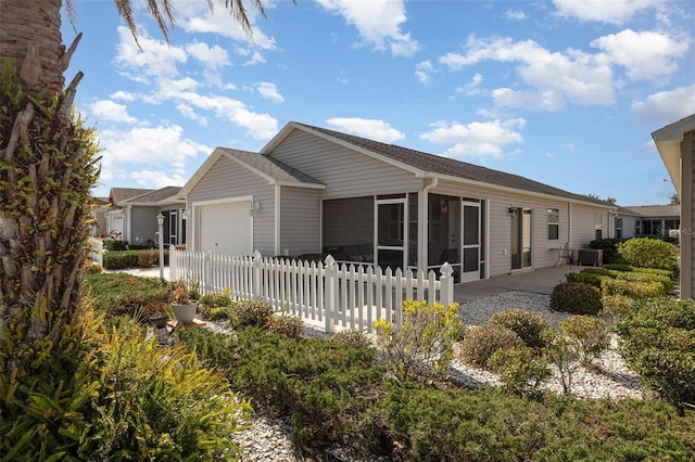 back of property featuring a garage, a sunroom, and fence