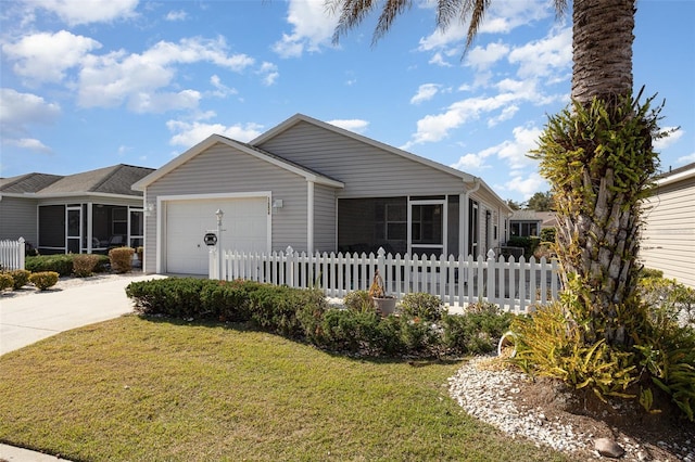 view of front of house featuring driveway, a fenced front yard, an attached garage, and a sunroom