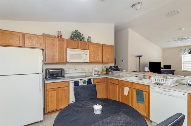 kitchen featuring lofted ceiling, a peninsula, white appliances, a sink, and open floor plan