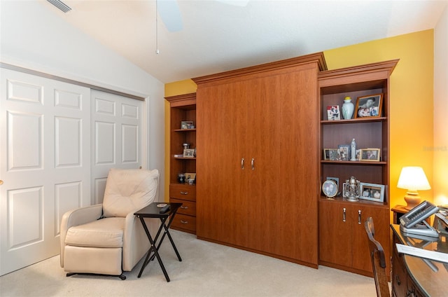 sitting room with light carpet, visible vents, and vaulted ceiling