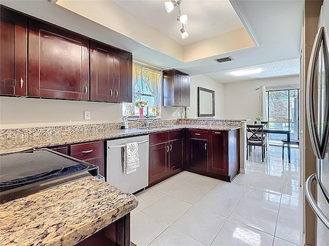 kitchen with a healthy amount of sunlight, visible vents, a tray ceiling, and stainless steel appliances