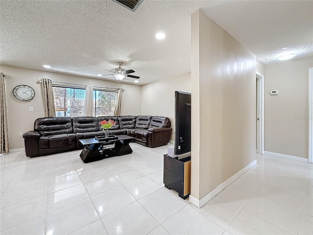 living room featuring a textured ceiling, light tile patterned flooring, visible vents, and a ceiling fan