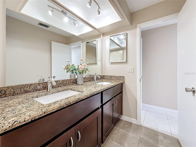 full bathroom with double vanity, visible vents, a raised ceiling, and a sink