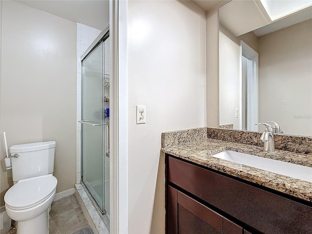 full bath featuring baseboards, a shower stall, toilet, and vanity