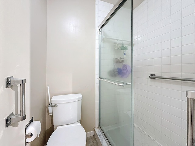 bathroom with a shower stall and toilet