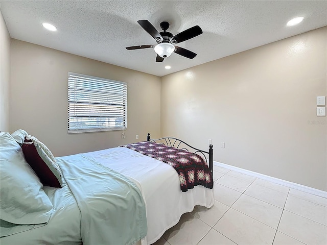 bedroom featuring a ceiling fan, recessed lighting, light tile patterned flooring, and a textured ceiling