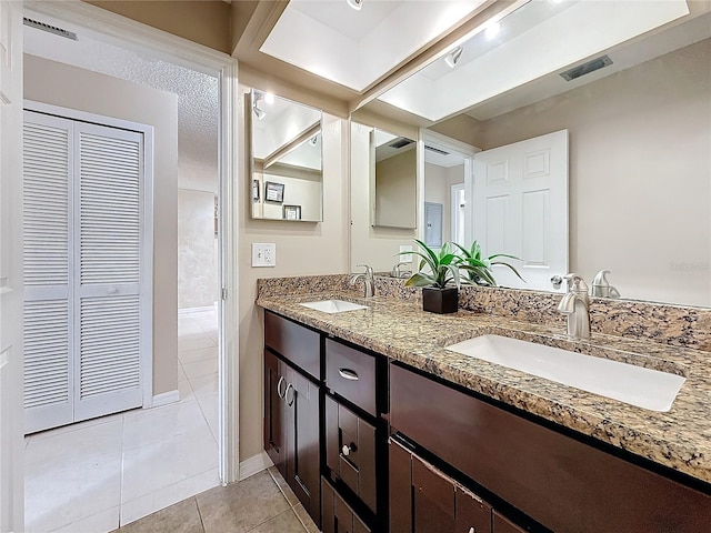 full bathroom with double vanity, a closet, visible vents, and a sink