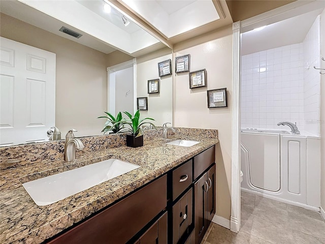 full bathroom featuring double vanity, visible vents, a sink, and a bath