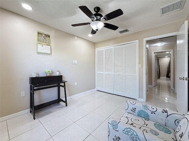 interior space with visible vents, a textured ceiling, and light tile patterned flooring