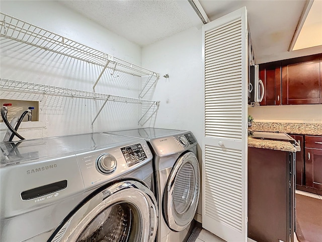 laundry room featuring laundry area, washer and clothes dryer, and a textured ceiling