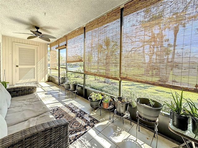 unfurnished sunroom with ceiling fan