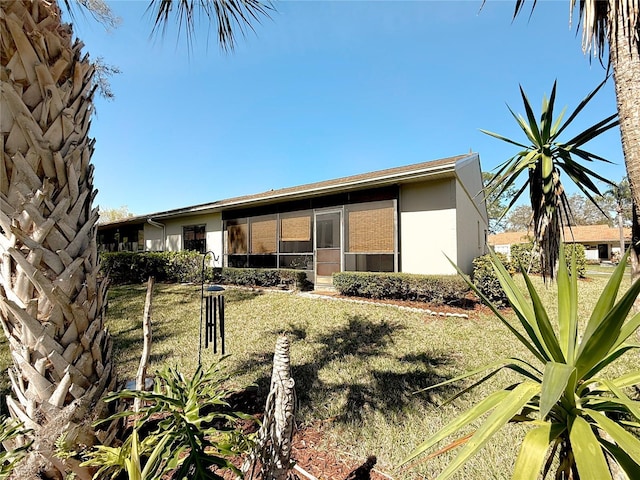 exterior space featuring stucco siding and a front yard