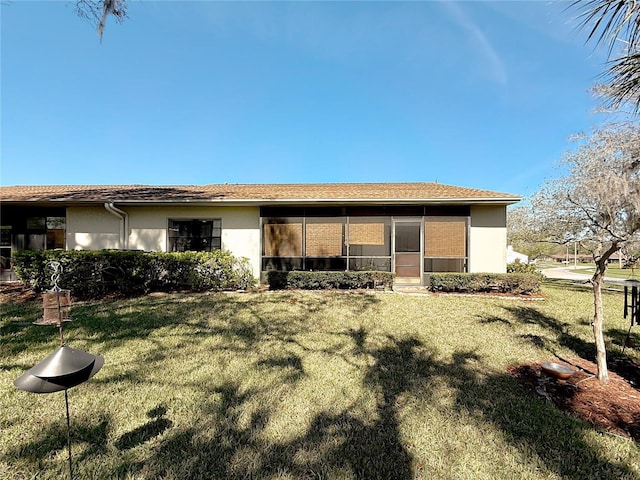 back of house with a yard and stucco siding