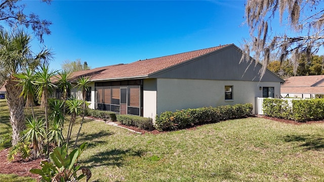 view of side of property with a yard, fence, and stucco siding