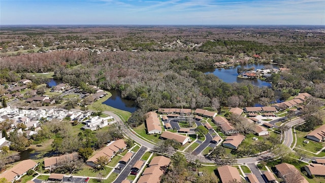 drone / aerial view featuring a water view, a residential view, and a view of trees