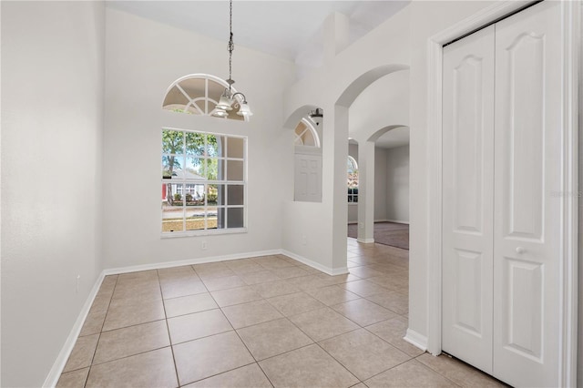 11611 Jordans Landing Ct, Riverview, FL 33569 - unfurnished dining area with light tile patterned floors, arched walkways, a chandelier, and baseboards