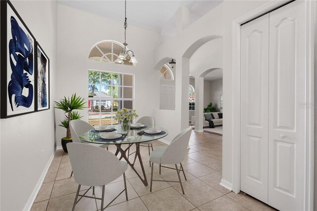 11611 Jordans Landing Ct, Riverview, FL 33569 - dining space featuring arched walkways, light tile patterned floors, baseboards, and a chandelier