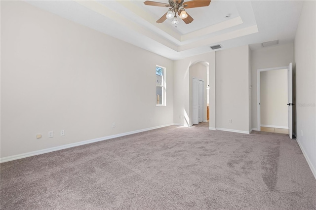 11611 Jordans Landing Ct, Riverview, FL 33569 - empty room featuring a tray ceiling, a ceiling fan, carpet floors, arched walkways, and baseboards