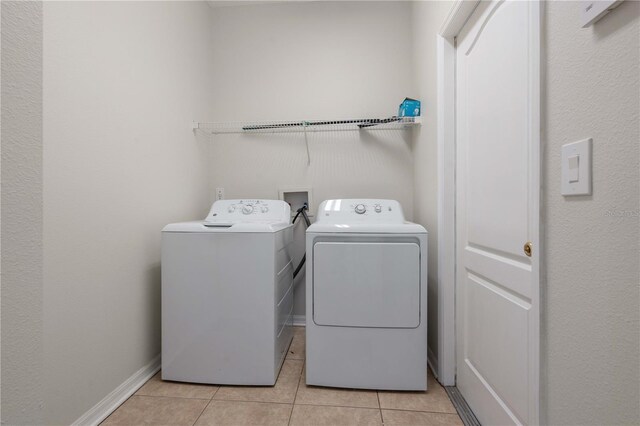 11611 Jordans Landing Ct, Riverview, FL 33569 - laundry room featuring washer and dryer, light tile patterned floors, and baseboards