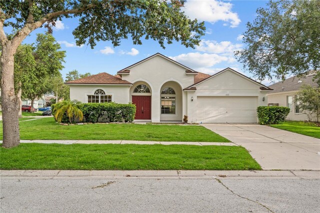 11611 Jordans Landing Ct, Riverview, FL 33569 - view of front facade with stucco siding, a garage, a front lawn, and concrete driveway
