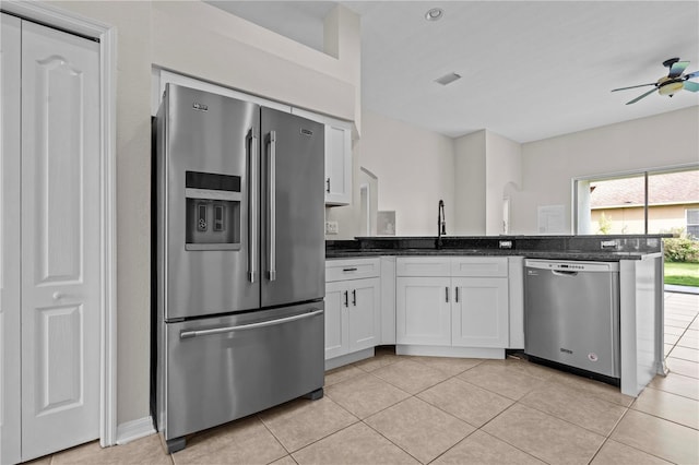 11611 Jordans Landing Ct, Riverview, FL 33569 - kitchen with appliances with stainless steel finishes, ceiling fan, white cabinets, light tile patterned flooring, and dark stone countertops