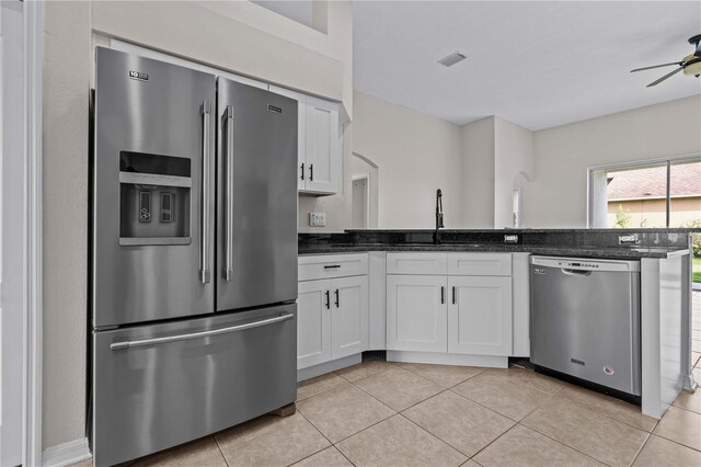 11611 Jordans Landing Ct, Riverview, FL 33569 - kitchen with stainless steel appliances, white cabinetry, a ceiling fan, dark stone counters, and light tile patterned floors
