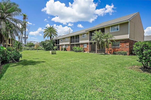 exterior space with brick siding and a front lawn