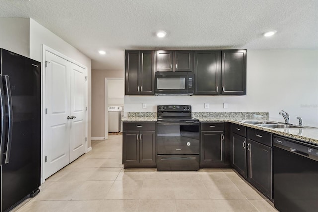8034 Broad Pointe Dr, Zephyrhills, FL 33540 - kitchen featuring black appliances, washer / dryer, a textured ceiling, light tile patterned floors, and light stone countertops
