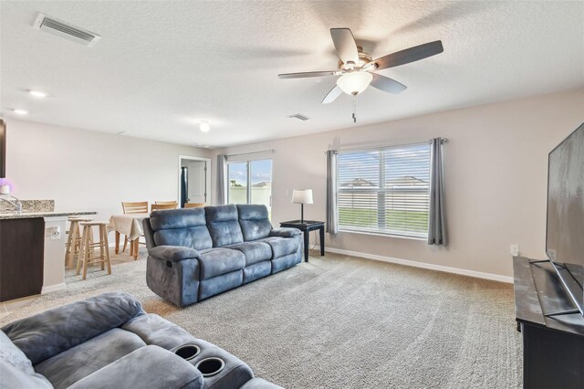 8034 Broad Pointe Dr, Zephyrhills, FL 33540 - living room with light colored carpet, a textured ceiling, and a ceiling fan