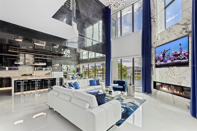 living room with a towering ceiling and a premium fireplace