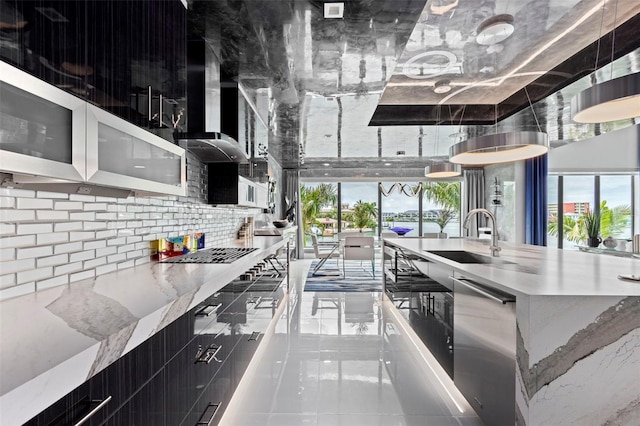 kitchen featuring decorative backsplash, stainless steel dishwasher, a sink, modern cabinets, and wall chimney exhaust hood