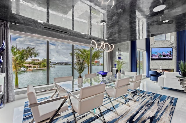 dining room featuring expansive windows, a high end fireplace, and a notable chandelier