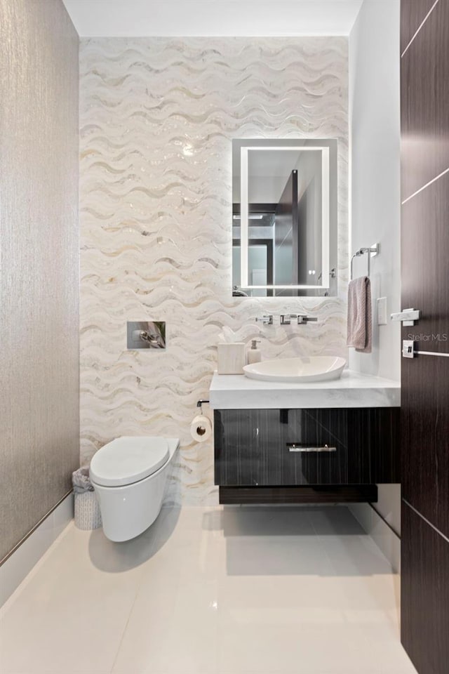 half bathroom featuring tile patterned flooring, vanity, and toilet