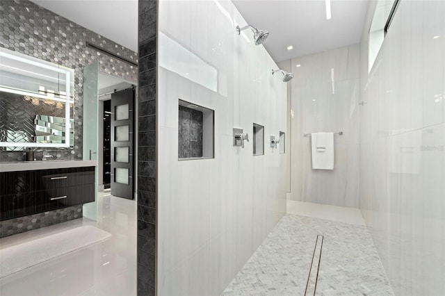 bathroom with a walk in shower, tile walls, and vanity